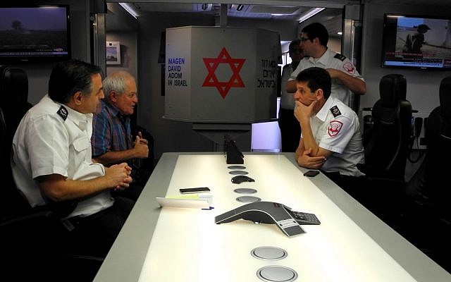 MK Haim Katz (second from left), MDA director general Eli Bin (seated on right) met with other MDA leaders in a mobile headquarters outside the Ashdod Magen David Adom office during a solidarity meeting on Wednesday. (photo credit: Melanie Lidman/Times of Israel) MK Haim Katz (second from left), MDA director general Eli Bin (seated on right) met with other MDA leaders in a mobile headquarters outside the Ashdod Magen David Adom office during a solidarity meeting on Wednesday. (photo credit: Melanie Lidman/Times of Israel)