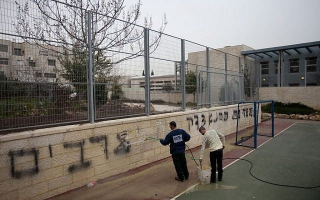 Workers clean the graffiti at the Jewish-Arab bilingual school in Jerusalem stating 'death to Arabs' and 'Kahana was right,' Feb 7, 2012 (Flash90) Workers clean the graffiti at the Jewish-Arab bilingual school in Jerusalem stating 'death to Arabs' and 'Kahana was right,' Feb 7, 2012 (Flash90)