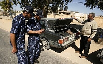 A Hamas security officers checks IDs after stopping a car at a checkpoint on the outskirts of the border between Rafah town in the southern Gaza strip and Israel to prevent any Palestinian collaborators from escaping into Israel, April 15, 2013 (Abed Rahim Khatib/Flash90) A Hamas security officers checks IDs after stopping a car at a checkpoint on the outskirts of the border between Rafah and Israel to prevent Palestinian collaborators from escaping into Israel, April 15, 2013 (Abed Rahim Khatib/Flash90)