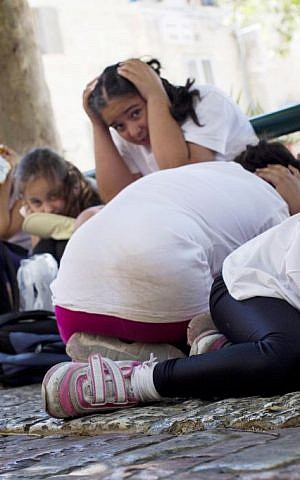 Illustrative photo of schoolchildren taking cover as part of an IDF Home Front Command drill simulating a bomb attack, May 27, 2013 (photo credit: Sarah Schuman/ Flash90)
