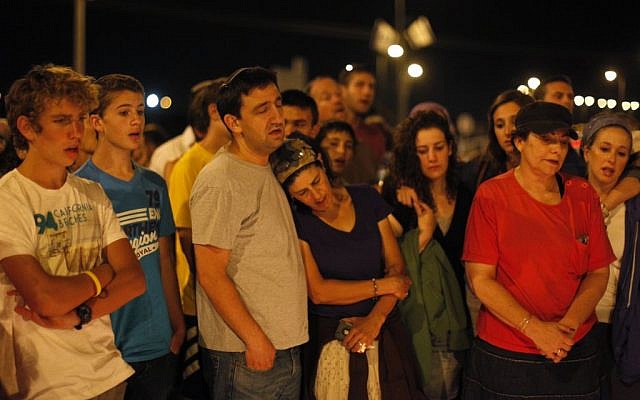 Israelis gather Monday night at the hitchhiking spot in the West Bank from where the three Jewish teenagers Eyal Yifrach, Naftali Fraenkel and Gil-ad Shaar were abducted on June 12. The teens' bodies were found in a field north of Hebron on Monday evening. (Photo credit: Yonatan Sindel/FLASH90)