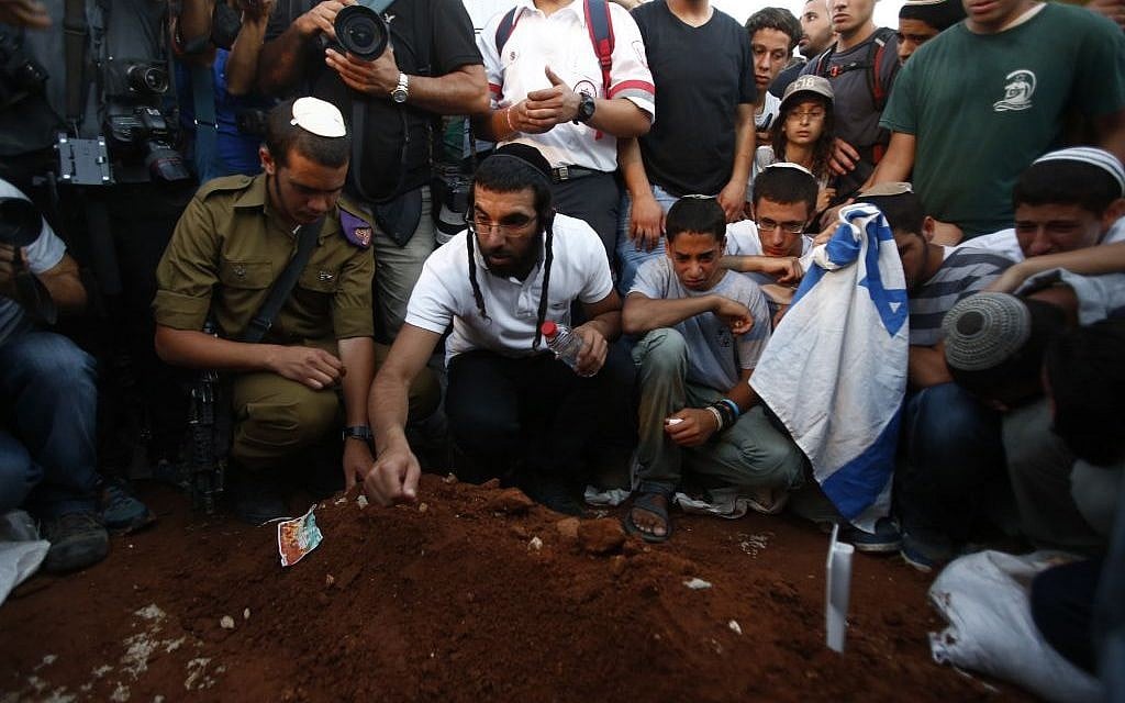 Men placing rocks on the grave of three slain teens. (photo credit: Yonatan Sindel/Flash90) Men placing rocks on the grave of three slain teens. (photo credit: Yonatan Sindel/Flash90)