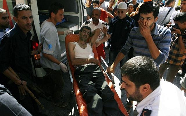 Palestinians carry an injured man outside the Nasser Hospital in Khan Yunis, in the southern Gaza Strip, on Tuesday, July 8, 2014. (photo credit: Abed Rahim Khatib /Flash90)
