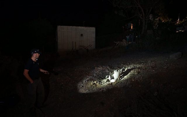 Israeli security forces inspect the site in Ramat Raziel, near Jerusalem, where a rocket fired by Palestinians in Gaza fell, Tuesday, July 8, 2014. (photo credit: Nati Shohat/Flash90)