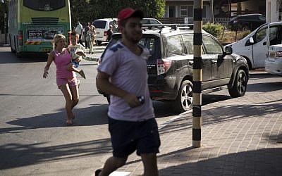 Israelis run for cover as the Color Red siren sounds in Sderot, southern Israel, on the third day of Operation Protective Edge, Thursday July 10, 2014. (photo credit: Hadas Parush/Flash90)