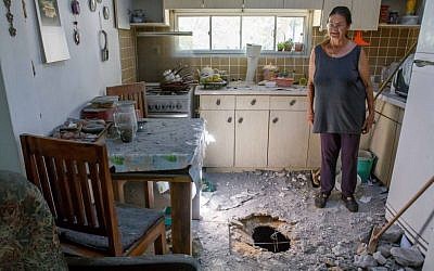 An Israeli woman surveys the damage caused to her parents' house in a community in southern Israel after it was hit by a rocket from Gaza,  July 11, 2014. (Photo credit: Flash90)