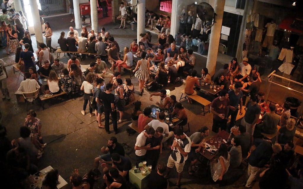 Israelis seen at a bar in Tel Aviv, central Israel. Several alarms sounded in the past few days warning about rockets fired from Gaza into Israel, and the Tel Aviv area. They were intercepted by the Iron Dome missile system. July 10, 2014. (photo credity: Miriam Alster/FLASH90)