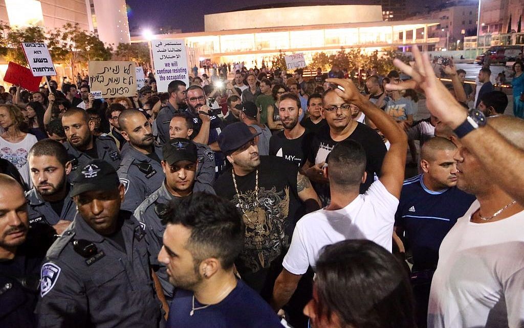 Groups of Israelis protest following an air raid siren warning of a rocket attack in Tel Aviv, on July 12, 2014. (Photo credit: FLASH90)