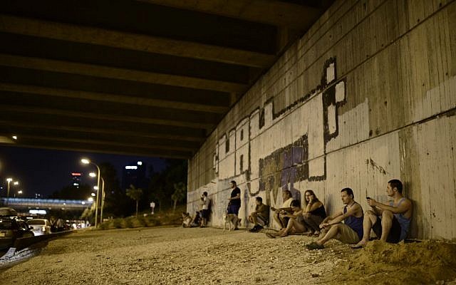 Israelis take cover as an alarm siren sounds, warning of incoming rockets in Tel Aviv, on the fifth day of Operation Protective Edge, Saturday, July 12, 2014 (photo credit: Tomer Neuberg/Flash90) Israelis take cover as an alarm siren sounds, warning of incoming rockets in Tel Aviv, on the fifth day of Operation Protective Edge, Saturday, July 12, 2014 (photo credit: Tomer Neuberg/Flash90)