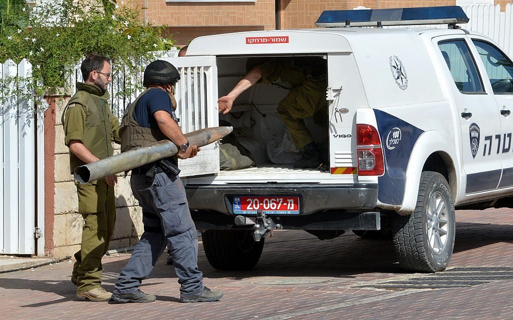 Israeli security carry away a missile, fired from Gaza into Israel, that landed in a yard in the Southern Israeli city of Ashkelon, Monday, July 14, 2014 (photo credit: FLASH90)