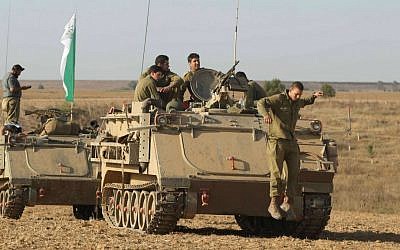 IDF soldiers seen near armored personnel carriers (APCs) by the southern Israeli border with Gaza, on the eighth day of Operation Protective Edge, July 15, 2014. (photo credit: Yossi Aloni/Flash90)
