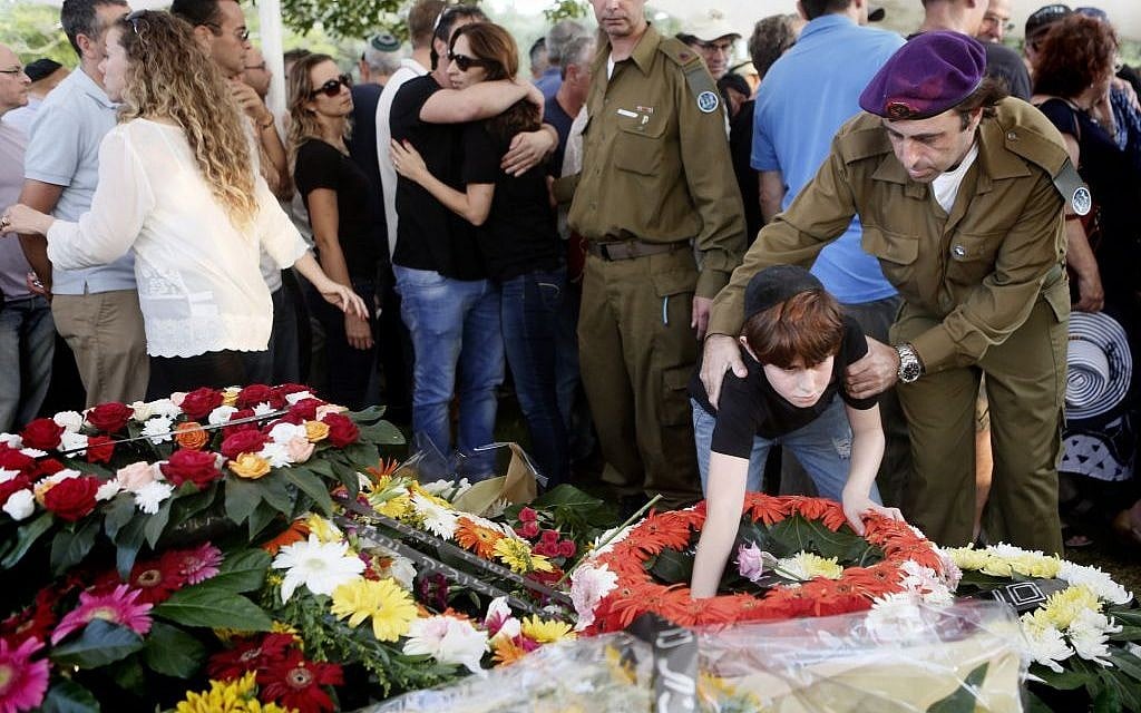 The son of IDF Major Amotz Greenberg (res.), 45, seen at the grave of his father during the funeral at the military cemetery in Hod HaSharon on Sunday, July 20, 2014. Greenberg was killed by Hamas terrorists who tunneled into Israel and opened fire on his army vehicle on July 19. (Photo credit: Miriam Alster/Flash90) The son of IDF Major Amotz Greenberg (res.), 45, seen at the grave of his father during the funeral at the military cemetery in Hod HaSharon on Sunday, July 20, 2014. Greenberg was killed by Hamas terrorists who tunneled into Israel and opened fire on his army vehicle on July 19. (Photo credit: Miriam Alster/Flash90)