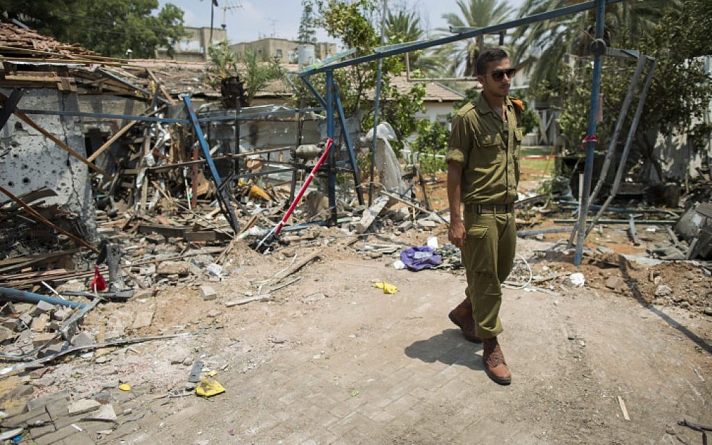 An Israeli soldier looks at the damage to a house following a rocket attack from the Gaza Strip on the town of Yehud, near Ben Gurion Airport, on July 22, 2014. (photo credit: Yonatan Sindel/Flash90) An Israeli soldier looks at the damage to a house following a rocket attack from the Gaza Strip on the town of Yehud, near Ben Gurion Airport, on July 22, 2014. (photo credit: Yonatan Sindel/Flash90)
