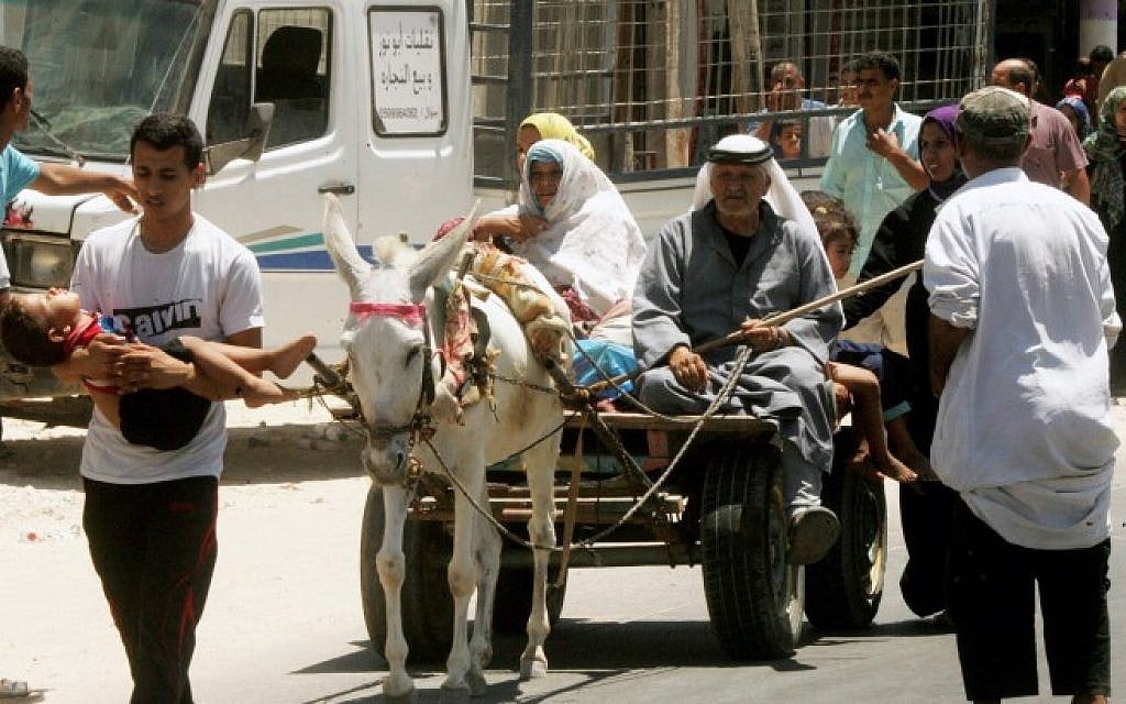 Palestinian families leave their neighborhood to a safer location as Israel's army continues shelling the area of Khan Yunis, in the southern Gaza Strip on July 24, 2014. (Photo credit: Abed Rahim Khatib/Flash90)