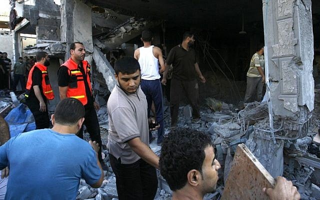 Palestinians search through the rubble of the destroyed house of Islamic Jihad spokesman Saleh Abu Hasanin following an Israeli air strike on it, reportedly killing him and two of his sons, in Rafah refugee camp in the northern Gaza Strip, Friday, July 25, 2014. (Photo credit: Abed Rahim Khatib/Flash90)