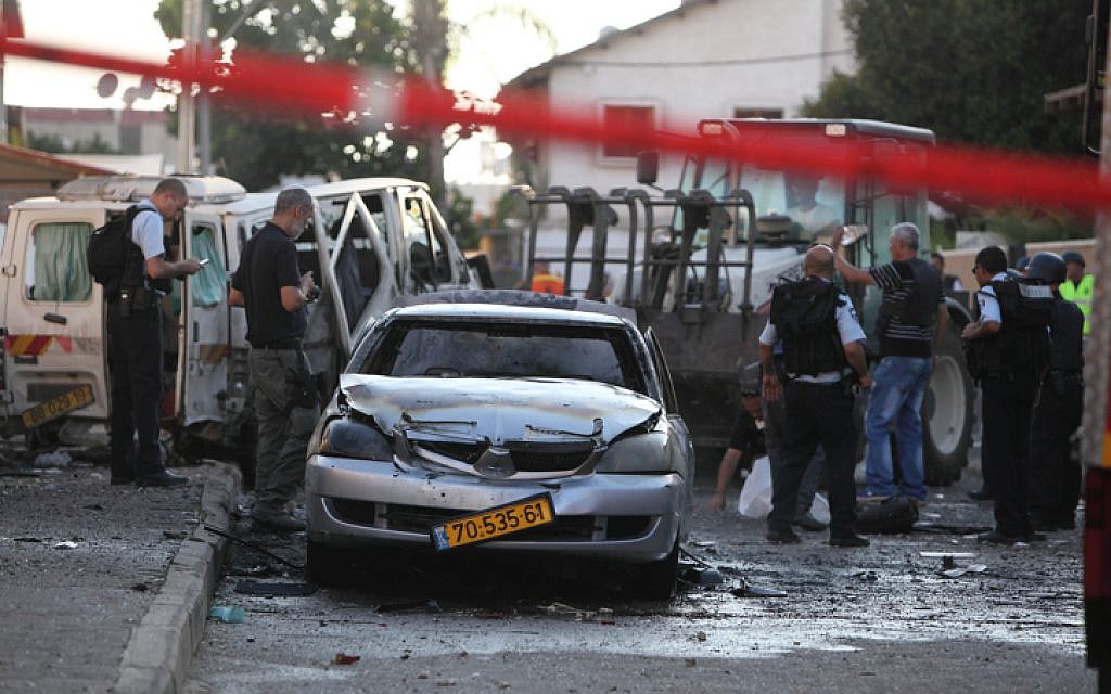 Israeli rescue personnel at the scene where a rocket fired from Gaza hit near a residential building in Kiryat Gat, moderately injuring one person and lightly wounding two more, Thursday, July 31, 2014 (photo credit: Yaakov Naumi/FLASH90)