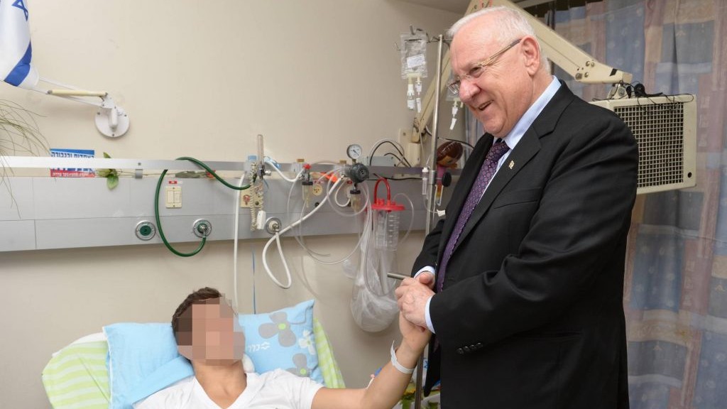 President Reuven Rivlin pays a visit to a soldier wounded in Operation Protective Edge, Monday, July 28, 2014. (photo credit: Mark Neiman/GPO)