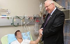 President Reuven Rivlin visiting an injured soldier in Beersheba, Monday. (photo credit: Mark Neiman/GPO)
