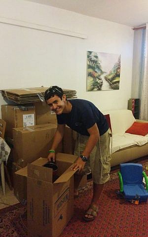 Tzvi Abbo helps the wife of a reserve soldier on duty pack up their house for their planned move up north (Courtesy Tzvi Abbo)