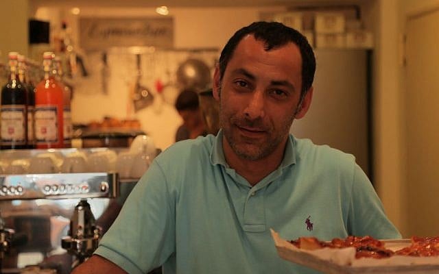 Iranian refugee Reza Dayeenavi at his cafe, Espresso Bar. (Micki Weinberg/The Times of Israel)