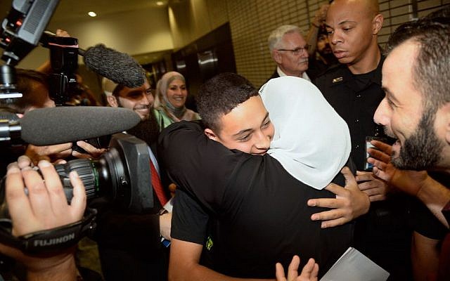 Tariq Abu Khdeir, the Palestinian-American teen who relatives allege was beaten by Israeli authorities earlier this month, is greeted by family, including his grandmother Huda Abu Khdeir, after he arrived at Tampa International Airport on Wednesday night, July 16, 2014, in Tampa, Fla. (AP Photo/The Tampa Tribune, Jason Behnken)