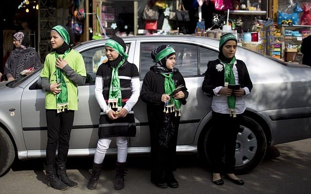 Israeli Arab girls look for passing cars to hand out Muslim prayer books, in the main street of the Arab town of Taibe, central Israel, January 2014. (photo credit: AP/Ariel Schalit/file) Israeli Arab girls look for passing cars to hand out Muslim prayer books, in the main street of the Arab town of Taibe, central Israel, January 2014. (photo credit: AP/Ariel Schalit/file)