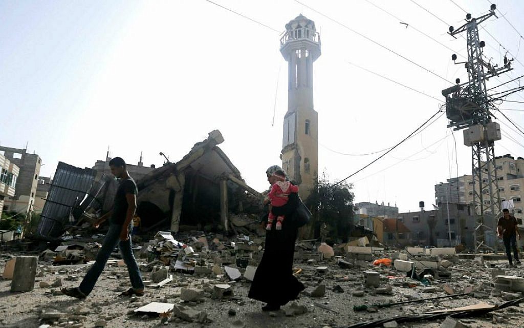 Illustrative photo of Palestinians walking past the ruins of a mosque after that was hit by an Israeli missile strike, in the central Gaza Strip (AP Photo/Hatem Moussa)