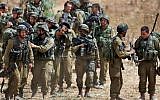 Israeli infantry soldiers get ready to walk to their armored personnel carriers to take up new positions on the Israel-Gaza border, Saturday, July 12, 2014. (AP Photo/Lefteris Pitarakis)