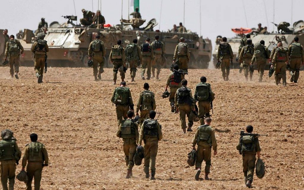 Israeli infantry soldiers walk to their armored personnel carriers to take up new positions on the Israel-Gaza border, Saturday, July 12, 2014. (AP Photo/Lefteris Pitarakis)