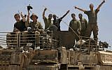 Israeli soldiers give the victory sign on the top of armored vehicle near the Israel Gaza border, Tuesday, July 29, 2014. (photo credit: AP Photo/Tsafrir Abayov)