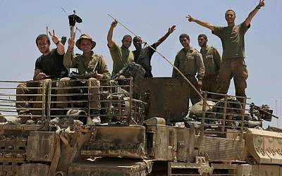 Israeli soldiers give the victory sign on the top of armored vehicle near the Israel Gaza border, Tuesday, July 29, 2014. (photo credit: AP Photo/Tsafrir Abayov)