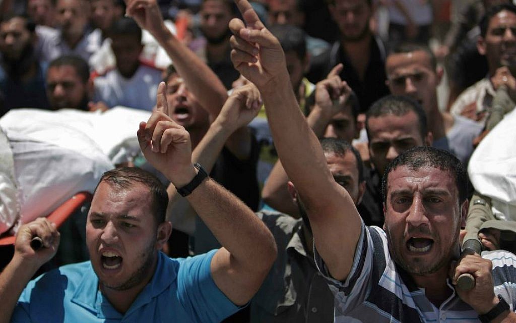 Palestinian mourners chant slogans as they carry the bodies of eight members of the Al Haj family, who were killed in an Israeli missile strike early morning, during their funeral in Khan Younis refugee camp, southern Gaza Strip on Thursday, July 10, 2014. (AP Photo/Khalil Hamra)