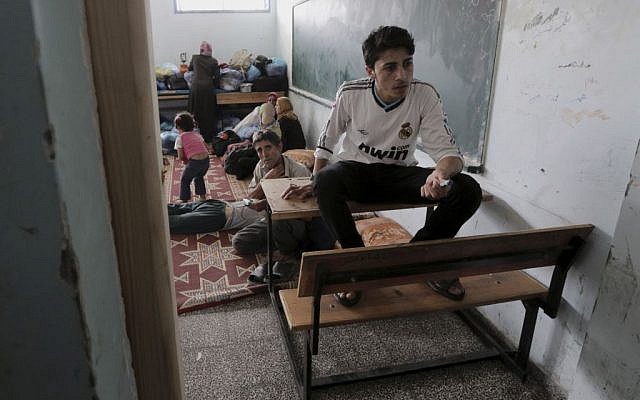 Palestinians take shelter at a United Nations school after having fled their homes in Gaza,  July 13, 2014 (photo credit: AP/Adel Hana)