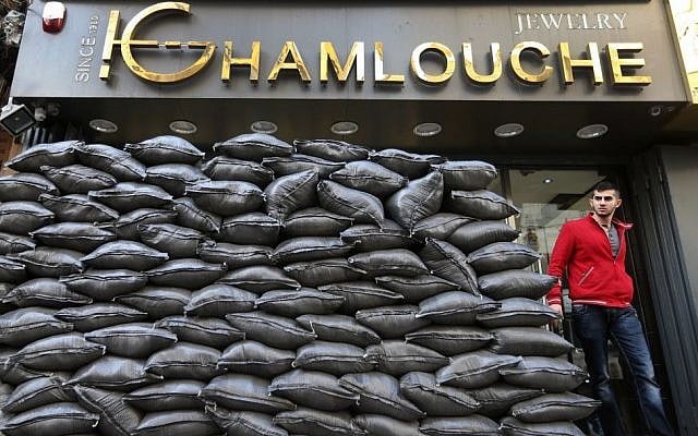 In this Tuesday, Jan. 28, 2014, file photo, a Lebanese man walks past sand barriers that were set in front of jewelry shop in a Shiite neighborhood in a southern suburb of Beirut. (photo credit: AP/Hussein Malla, File) In this Tuesday, Jan. 28, 2014, file photo, a Lebanese man walks past sand barriers that were set in front of jewelry shop in a Shiite neighborhood in a southern suburb of Beirut. (photo credit: AP/Hussein Malla, File)