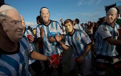 Soccer fans of the Argentina national soccer team wear masks with faces of Pope Francis and Argentine soccer player Lionel Messi during a live telecast in July of the soccer World Cup semifinal match between Argentina and Netherlands, inside the FIFA Fan Fest area on Copacabana beach, in Rio de Janeiro, Brazil. (AP Photo/Silvia Izquierdo, File)