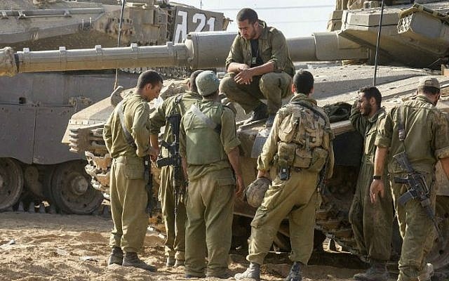 Israeli soldiers next to a Merkava tank stationed at an army deployment area near Israel's border with the Gaza Strip, on July 24, 2014. (photo credit: AFP/Jack Guez) Israeli soldiers next to a Merkava tank stationed at an army deployment area near Israel's border with the Gaza Strip, on July 24, 2014. (photo credit: AFP/Jack Guez)