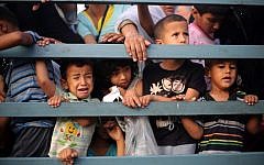 Palestinian children stand in the back of a truck as families leave their neighborhoods to safer locations amid continuing Israeli bombardment of Khan Yunis in the southern Gaza Strip, on July 24, 2014 (AFP/Bilal Telawi)