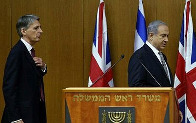 Israeli Prime Minister Benjamin Netanyahu (R) leaves the podium at the end of a joint press conference with British Foreign Secretary Philip Hammond (L) on July 24, 2014 at the Knesset in Jerusalem (photo credit: AFP PHOTO/Gali Tibbon) 