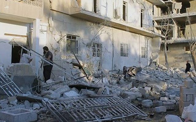 This photo taken on Wednesday, June 25, 2014, and provided by the anti-government activist group Aleppo Media Center (AMC), which has been authenticated based on its contents and other AP reporting, shows Syrians inspecting the rubble of a damaged houses following a Syrian government airstrike in Aleppo, Syria (photo credit: AP Photo/Aleppo Media Center AMC) This photo taken on Wednesday, June 25, 2014, and provided by the anti-government activist group Aleppo Media Center (AMC), which has been authenticated based on its contents and other AP reporting, shows Syrians inspecting the rubble of a damaged houses following a Syrian government airstrike in Aleppo, Syria (photo credit: AP Photo/Aleppo Media Center AMC)