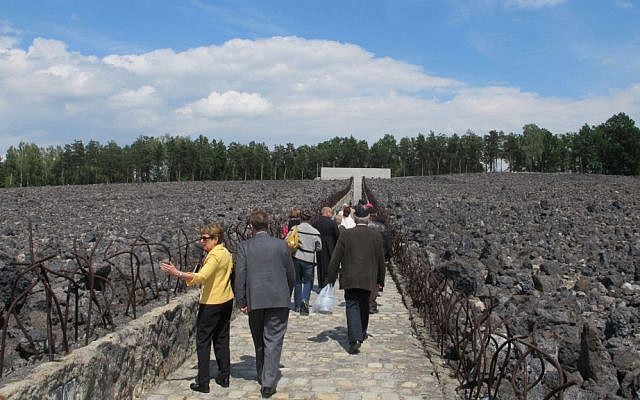 Participants in the ceremony marking the 10th anniversary of the memorial at the Belzec death camp walk through the field of slag toward the memorial wall. (Ruth Ellen Gruber/JTA) Participants in the ceremony marking the 10th anniversary of the memorial at the Belzec death camp walk through the field of slag toward the memorial wall. (Ruth Ellen Gruber/JTA)