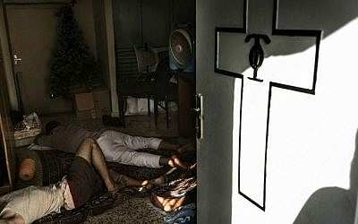 Displaced Palestinians sleep on the floor inside Gaza City's Greek Orthodox church on July 23, 2014 (photo credit: AFP/Marco Longari)_