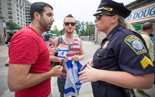 Pro-Israel activists Avi Levi (left) and Brett Loewenstern speak with a police officer following their extraction from 'pushing and shoving' by anti-Israel protesters (photo credit: Elan Kawesch/The Times of Israel)