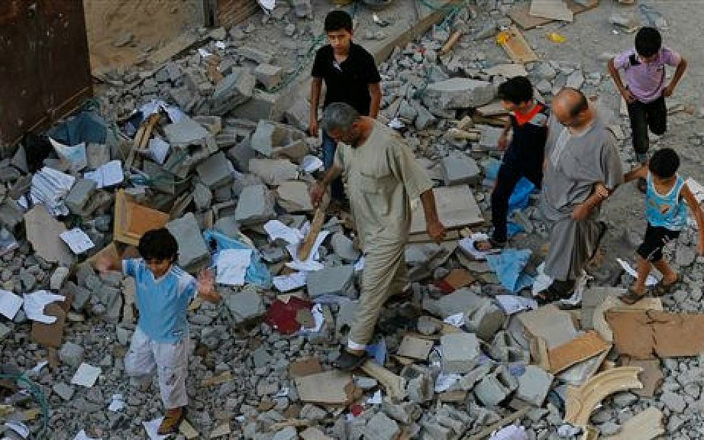 Residents walk on debris from a destroyed house in Beit Lahiya, in northern Gaza strip, Saturday, July 19, 2014 (photo credit: AP/Lefteris Pitarakis)