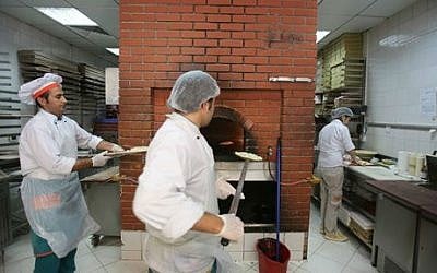 In this Monday, May 19, 2014 photo, employees work in the kitchen of a Man'oushe Street restaurant in Dubai, United Arab Emirates (photo credit: AP/Kamran Jebreili) 