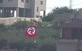 A Nazi flag flying over the West Bank town of Beit Ummar (photo credit: YouTube screen cap/Tazpit News Agency)