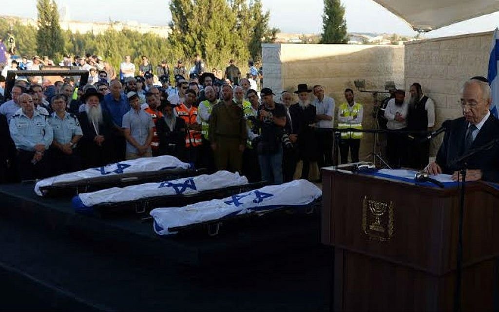 President Shimon Peres delivering a eulogy next to the flag-draped bodies of Naftali Fraenkel, Gil-ad Shaar and Eyal Yifrach at their funeral July 1, 2014 (photo credit: Chaim Tzach)