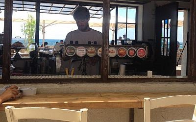 Roi Sterman, a Bar Ilan University student who bartends at the Jaffa port, says business has been bad for two months, but there is a steady stream of tourists from the West Bank, celebrating Eid al-Fitr (photo credit: Jessica Steinberg/Times of Israel)