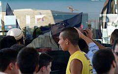 Protesters bang on a bus and put stickers that call for 'revenge' in front of its Arab bus driver during a large protest in central Jerusalem, on July 1, 2014 (photo credit: Mendy Hechtman/Flash90)