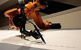 A robot writes a Torah at an installation in the Jewish Museum in Berlin, Germany, on Thursday, July 10, 2014. (photo credit: AP/Markus Schreiber)