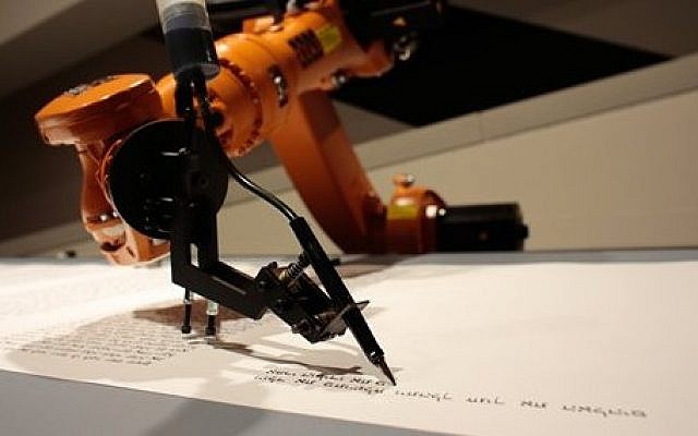 A robot writes a Torah at an installation in the Jewish Museum in Berlin, Germany, on Thursday, July 10, 2014. (photo credit: AP/Markus Schreiber) A robot writes a Torah at an installation in the Jewish Museum in Berlin, Germany, on Thursday, July 10, 2014. (photo credit: AP/Markus Schreiber)